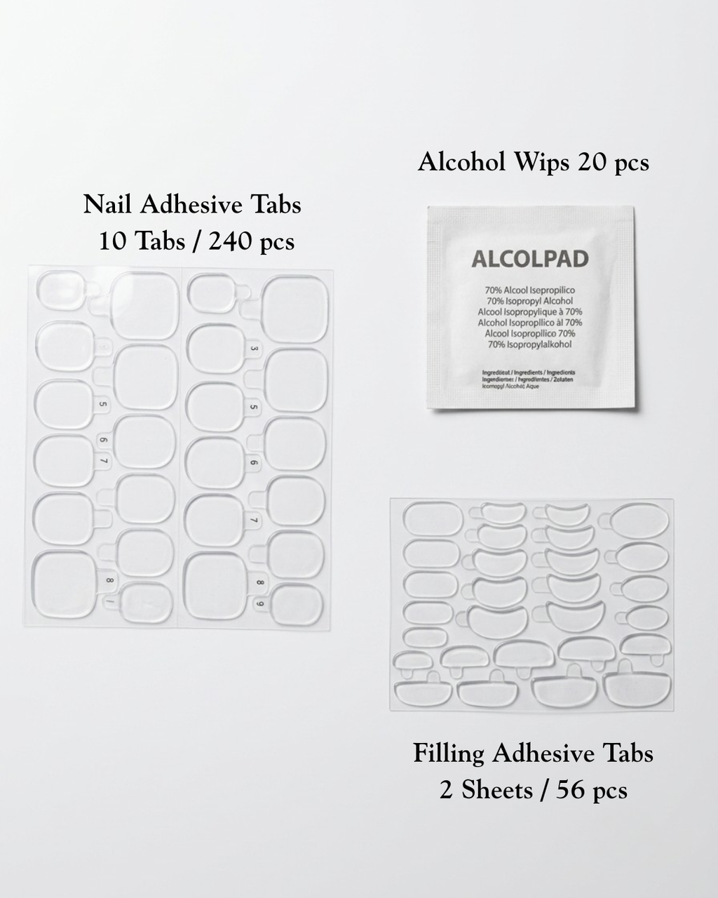 Nail care kit components, a sheet of clear nail adhesive tabs, a packet of alcohol wipes, a sheet of clear filling adhesive tabs